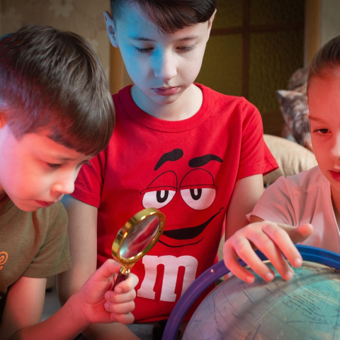 enfants qui regardent un globe terrestre